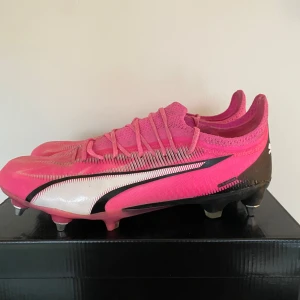 Rosa fotbollsskor från Puma - Snygga rosa fotbollsskor från Puma. Sparsamt använda endast en vecka så så gott som nya. Storlek 41 men passar även 41,5. Järndobbar tillkommer endast