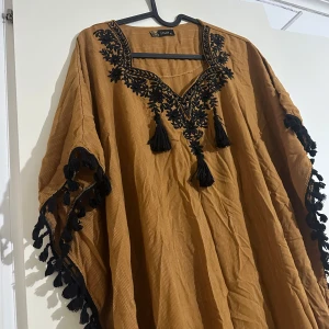 Brun långklänning med svarta broderier - Lång kläning använd enstaka gånger xl