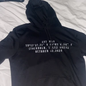 Svart Ant Wan hoodie  - Snygg svart Ant Wan hoodie med tryck på både fram- och baksida. Perfekt för dig som gillar unika och uttrycksfulla plagg. Pris kan diskuteras men börjar med det som står