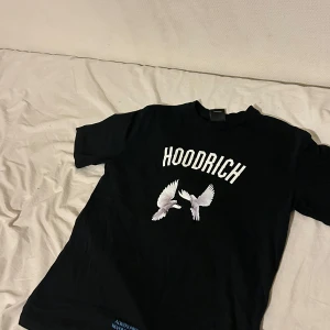Svart t-shirt från Hoodrich - Snygg svart t-shirt från Hoodrich med tryck av vita duvor och texten 'From Nothing To Something'. Perfekt för en avslappnad stil.
