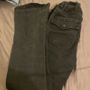 Svarta bootcut jeans från 157 - Säljer ett par svarta bootcut jeans från 157. De har en klassisk design med knapp och dragkedja framtill samt fickor bak. Perfekta för en avslappnad stil.