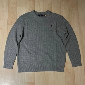 Polo Ralph Lauren Stickad tröja - Säljer en stilren grå stickad tröja från Polo Ralph Lauren. Nyskick 10/10 rekommenderar starkt ! 