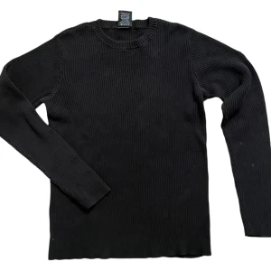 Svart ribbad tröja från Polo Jeans Company - Snygg svart ribbad tröja från Polo Jeans Company. Perfekt för kyligare dagar med sin långärmade design och klassiska look. Passar bra till både jeans och chinos.