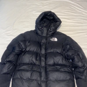 Svart dunjacka från The North Face - Säljer en svart dunjacka från The North Face. Jackan har en pufferdesign med lång ärm och en praktisk huva. Perfekt för kalla dagar. 9/10 skick, nypris 4500, mitt pris 2599 pris kan diskuteras, kvitto finns.