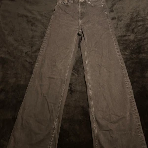 Svarta bootcut jeans från Weekday - Säljer ett par svarta jeans från Weekday i storlek 24/34. De har en klassisk femficksdesign och är tillverkade i ett slitstarkt material. Perfekta för en stilren look.