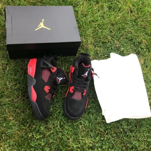 Svarta och röda Nike Air Jordans - Säljer ett par snygga Nike Air Jordans i svart och rött. Skorna har en cool design med snörning och den klassiska Jumpman-loggan. Perfekta för både vardag och fest!