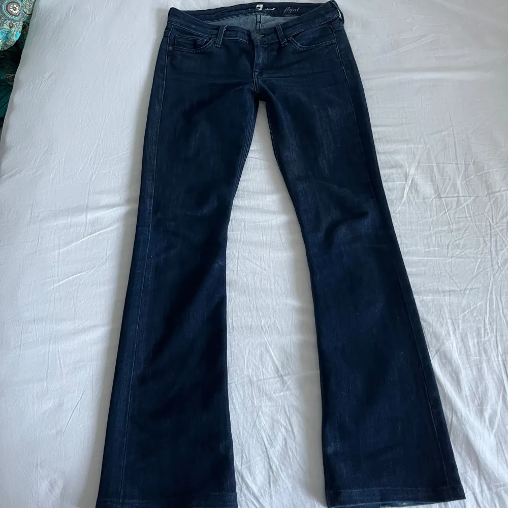 Super snygga lowwaist bootcut jeans från 7 for all mankind💗De är vintage och har mindre slitningar,(längst ned på båda benen) men är i övrigt fint skick. Innerbenslängd 77cm, midjemått 39cm. Jeans & Byxor.