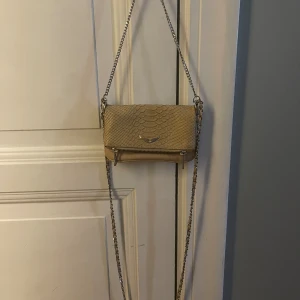 Zadig Voltaire rock clutch nano - Använd men i fint skick. Säljer på grund av att den inte kommer till användning längre. Det här är den lilla modellen. Rosa/beige 🤍