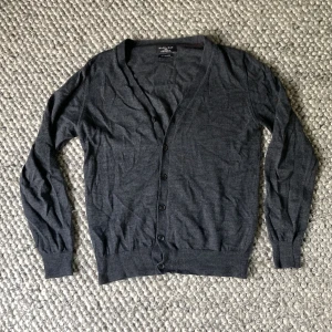 Zara Cardigan - En snygg cardigan/kofta i ylle från Zara. Storlek M och den är lagad på axeln och hålet för nedersta knappen är lite uttänjt annars är den i gott skick. Hör av dig vid minsta fundering!