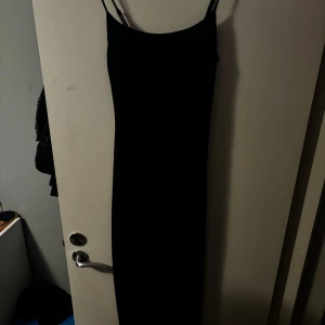 Svart långklänning från Bik Bok - Säljer en elegant svart långklänning från Bik Bok i storlek XS. Klänningen är ärmlös och har en tight passform som framhäver figuren. Perfekt för festliga tillfällen eller en utekväll! Helt oanvänd med prislapp kvar.