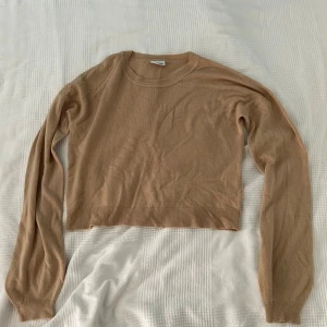 Beige stickad tröja från Noisy May - Säljer en superfin beige stickad tröja från Noisy May. Tröjan har långa ärmar och en croppad passform.