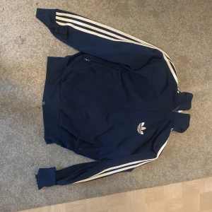 En snygg mörkblå adidas jacka i storlek S/M - Jag säljer en mörkblå adidas jacka i storlek S/M eftersom den inte riktigt är min stil längre. Bra kvalitet men inga defekter. Tar emot prisförslag 💝