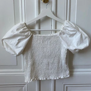 Vit topp med puffärmar  - Vit topp med puffärmar från Gina Tricot i storlek M. Endast använt en gång så skicket är som nytt! 