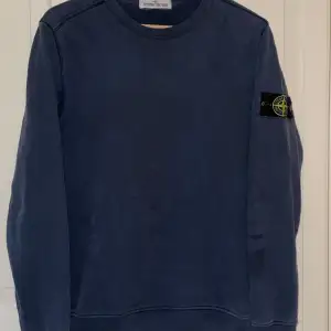 En (äkta) Stone Island crewneck tröja / sweatshirt i mycket fint skick. Mörkblå/gråblå.  Storlek Small. Den sitter bra på dig som är mellan 170 till 178 lång.  Väldigt mjuk och skön tröja till hösten. 