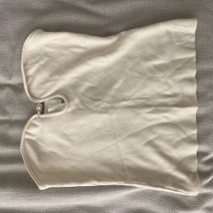 Tubtopp - Fin tubtopp med en supersöt detalj framtill. Aldrig använd. Storle M. Cremefärgad.