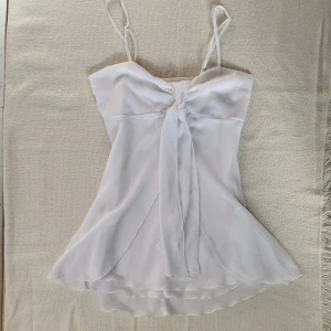 Topp med knyte - Supersött sommrig topp med knyte framtill. Den har nära passform och är genomskinlig nertill. Kom gärna med prisförslag!