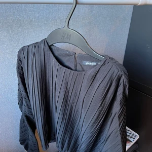 Svart blus  - Svart pilsserad blus från Gina💕 knäppning med en knapp i ryggen. Använd ett fåtal gånger 