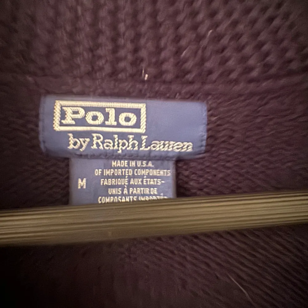 Säljer en snygg mörkblå stickad kofta från Polo Ralph Lauren. Den har en cool amerikansk flagga på ryggen och RL-bokstäver broderade i rött. Koftan har långa ärmar och knappar framtill. Perfekt för höst och vinter!. Tröjor & Koftor.