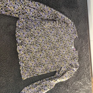 blommig blus från vero moda - jag säljer en gullig blus från vero moda, aldrig använt och är nästan helt ny! den är i storlek 152 men är ganska stor i storlek skulle jag säga!💕