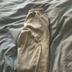 Grå mjukisbyxor - Säljer ett par grå mjukisbyxor i bra skick. De är superbekväma med elastisk midja och perfekt för en chill dag hemma eller en snabb tur till affären. Materialet är mjukt och skönt, vilket gör dem till ett måste i garderoben. Passar perfekt för höst och vinter! Har tvättat dem ett par gånger så de har blivit lite mindre mjuka men annars helt okej. 
