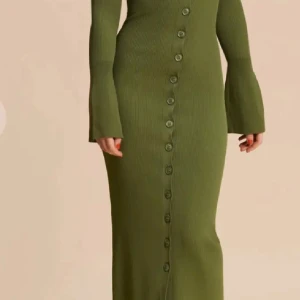 Grön ribbad klänning från Adoore - Säljer en superfin grön ribbad långklänning från Adoore. Den har en v-ringad design med knappar hela vägen ner och långa ärmar. Perfekt för höst och vår, och den sitter riktigt snyggt på kroppen. Passar både till vardags och fest!