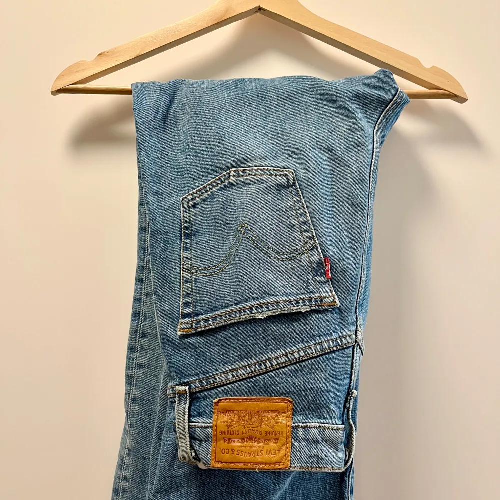 Snygga Levi's jeans i modellen Ribcage Straight. Jeansen är i en ljusblå färg och har en hög midja. De har en rak passform och har ett medvetet hål vid ena benet. Storlek W 26 / L 27 -  i fint skick. 🤍. Jeans & Byxor.