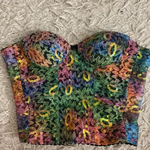 multicolored lace corset  - Svart korsett med flerfärgad spets och paljetter. Den perfekta festtoppen och statement piecen. Står att den är i storlek M men passar även S och L beroendes på hur hårt/löst du spänner korsetten. Inga synliga defekter, i fint skick och så vacker!