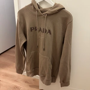 Prada hoodie 😍 - Säljer denna Prada hoodien med prislappar kvar! Storlek S, färgen är beige/brun 