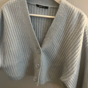 Ljusgrå ribbad kofta från Gina Tricot - Superfin ljusgrå kofta från Gina Tricot i ribbat material. Knappar framtill och har långa ärmar och tight till slutet vilket gör ärmarna ”puffiga”. Hyfsat nopprig. Hör av dig vid frågor eller bild på💕💕
