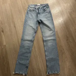 Säljer ett par snygga blå jeans från Zara i storlek EUR 38. De har en straight passform och är högmidjade med slits längst ner. Perfekta för en avslappnad stil och kan matchas med nästan vad som helst. Använda men i bra skick!