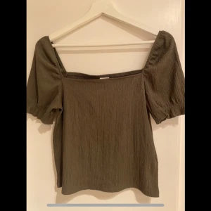 Helt ny! Olivgrön topp från H&M - Säljer en olivgrön topp från H&M i mycket bra skick. Oanvänd! 