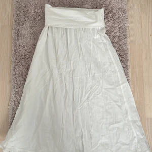 Vit långkjol - Säljer en elegant vit långkjol i ett mjukt och lätt material. Perfekt för sommarens alla tillfällen, från strandhäng till fest. Kjolen har en enkel och stilren design med en bred linning som ger en bekväm passform. Passar perfekt till både vardag och festliga tillfällen. 🏖️✨