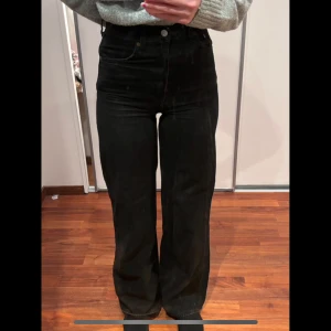 Svarta jeansbyxor från Levis - Snygga svarta högmidjade jeansbyxor från Levis med en klassisk femficksdesign. Byxorna har en rak passform och är perfekta för en stilren look. De är tillverkade i ett slitstarkt material som ger en bekväm känsla hela dagen.