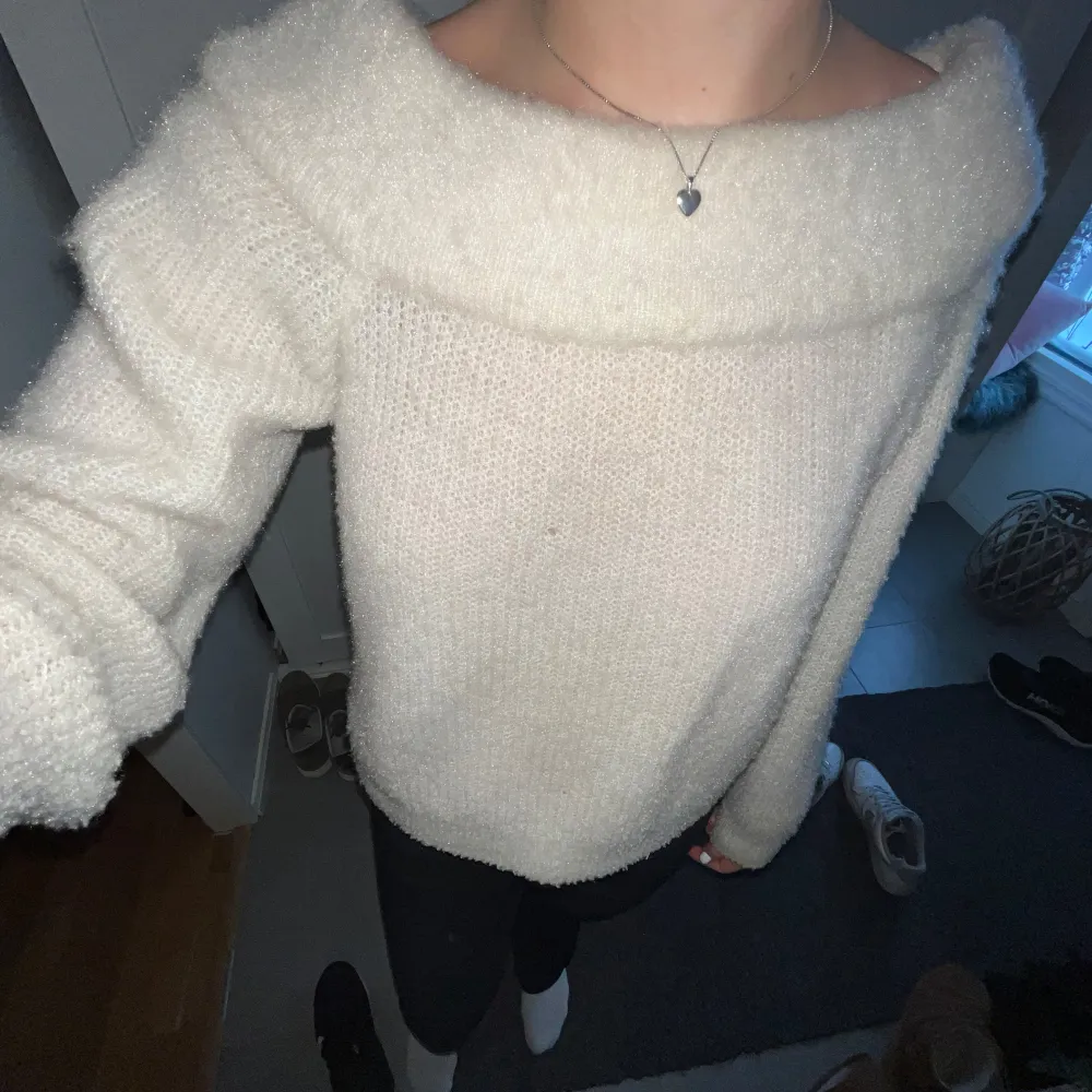 Mysig vit stickad tröja med en bred krage som ger en avslappnad look. Perfekt för kyliga dagar och passar bra till både jeans och kjol.. Neuletakit & Villapaidat.