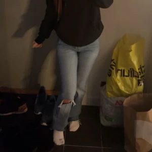 Gina jeans - Jeans från Gina Tricot i storlek 32. Jeansen har en medelhög midja och har ett stort hål vid knät. De är i bra skick, dock har jag klippt dem längst ner då de var för långa för mig. Säljer då de inte kommer till användning💞köpte dessa för 499kr
