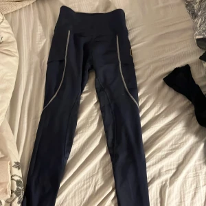 Svarta ridbyxor från Maya Delorez - Snygga svarta ridtights från Maya Delorez med hög midja och mobilfickor på sidorna. Använda få gånger. De är helskodda och perfekta för dressyr, funkar super för hoppning också ❤️❤️