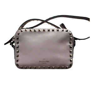 Valentino - Snygg ljusrosa rockstud valentinoväska, äkthetskontrollerad och dustbag medföljer. Väskan har utom en liten fläck inuti (syns på bild) inga som helst defekter! 