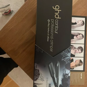 ghd Contour Professional Crimper - Säljer en helt ny  ghd Contour Professional Crimper, perfekt för att skapa volym och textur i håret. Den kommer i en elegant svart design med guldiga detaljer. Perfekt för att ge håret en ny look med stil och volym. I original kartong aldrig uppackade 