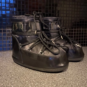 Moonboots icon low glance - Svarta glansiga moonboots, använda litegrann några gånger, har några små repor på sidorna (inget som syns när de sitter på), annars jättefina! Ordinarie pris 2285kr, köpta på Zalando, säljer då de inte används längre☺️tillkommer en påse till skorna!!