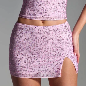 Rosa glittrig kortkjol - Trendig rosa kortkjol med glittrande stenar och en liten slits på sidan. Perfekt för att sticka ut på festen. Nypris 850kr.