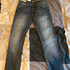 Blå skinny jeans från Jack & Jones - Helt par nya byxor skinny jeans från Jack & Jones, modell Liam. De har en klassisk femficksdesign och en smal passform som ger en modern look. Perfekta för en stilren vardagsstil. Säljer dessa byxor pågrund av att jag fick det som en present då den tyvärr inte passade mig