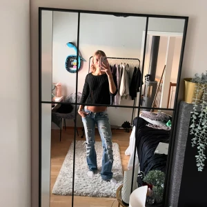 Svart hålstickad croppad tröja med trekvartsärmar - Säljer en svart ribbad croppad tröja med långärmade ärmar. Perfekt för en trendig och avslappnad stil. Passar bra till jeans eller kjol.