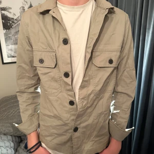 Beige overshirt - Riktigt najs beige overshirt från H&M. Stilren och passar till allt. Lite skrynklig haha men därav nedsatt pris. Bara att stryka till👊🏻 Storlek xs men passar S.