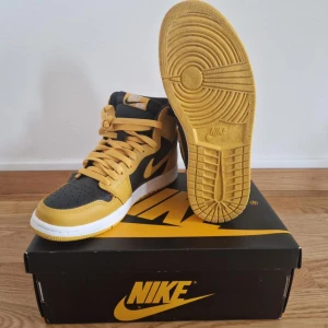 Nike Air Jordans 1 ”pollen” - Snygga Nike Air Jordans i svart och gul med autenticitetsmärke. Skorna är riktigt feta men tyvärr för små för mig nu. Köpta på sotckx. Följer med 2 par extra skosnören.