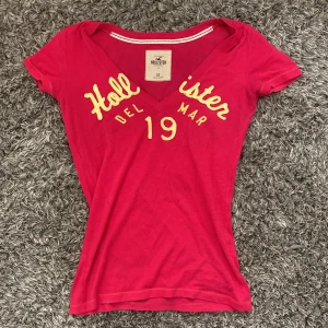 Hot pink  t-shirt från Hollister - Snygg rosa topp från Hollister. Ser lite röd/orange ut i bild men är hotpink! Och storleksmässigt passar den mer en s en xs