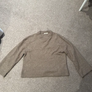 Beige tröja från Gina Tricot - Säljer en stilren beige tröja från Gina Tricot i storlek XS. Tröjan är tillverkad i en mjuk blandning av material och har långa ärmar med ribbade muddar. Perfekt för en avslappnad look.