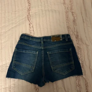 Jeansshorts  - Snygga jeansshorts i mörkblå denim med rå kant och fina kanter.
