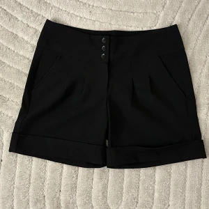 NYA Svarta shorts från Lindex - Snyggaste shortsen från Lindex 😍 Finbyxmodell! Oanvända, har bara blivit liggande då jag köpte fel storlek. Snygga detaljer och sitter jättefint! 