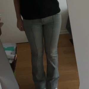 Ljusblå bootcut jeans från Bershka - Snygga ljusblåa bootcut jeans med en klassisk design. De har en låg midja och en stilren söm längs benen som ger en smickrande siluett. Perfekta för en avslappnad men ändå stilren look. 