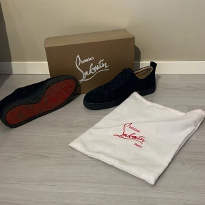 Mörkblå  sneakers från Christian Louboutin  - Snygga mörkblå sneakers från Christian Louboutin utan spikar  med den ikoniska röda sulan. I storlek 43-44, bra skick på skorna. Får med box och även dustbag. Hör av er vid frågor. 